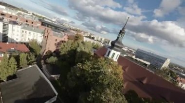Bu nefes kesici FPV insansız hava aracı görüntüsü sizi hareketli bir şehrin kalbine doğru heyecanlı bir yolculuğa çıkarıyor. Videoda kiliseler de dahil olmak üzere ikonik kent simgelerinin çarpıcı hava manzaraları yer alıyor.