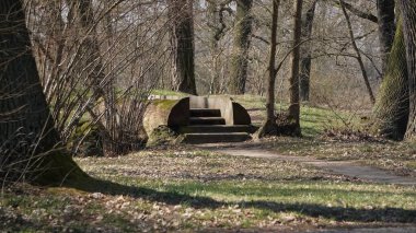 Arkaplanda nehir üzerindeki ahşap köprü, nehir ve çevresindeki doğa manzaralı bir manzara yaratır..