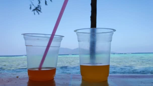 Δύο Ποτά Πορτοκαλιού Χυμών Πλαστικά Κύπελλα Από Την Παραλία — Αρχείο Βίντεο