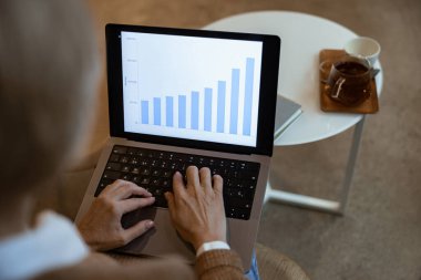 Orta yaşlı iş kadını kafede dizüstü bilgisayarında istatistiksel verilerle çalışıyor. Serbest çalışma kavramı