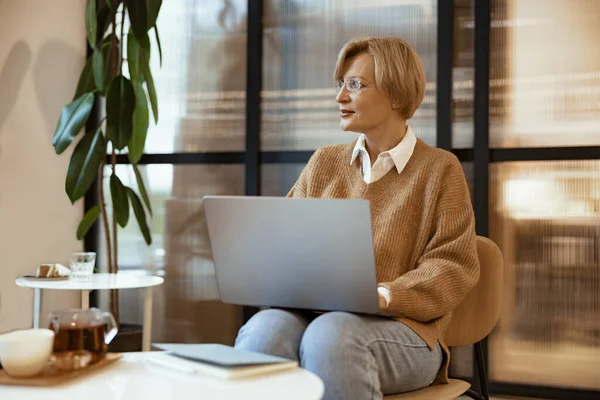 穿着休闲装的中年女商人在合作中使用笔记本电脑 自由工作概念 — 图库照片