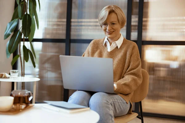 穿着休闲装的中年女商人在合作中使用笔记本电脑 自由工作概念 — 图库照片