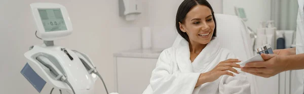 Szczęśliwa Biała Kobieta Spędza Czas Gabinecie Kosmetologa Wybierając Produkt Pielęgnacyjny — Zdjęcie stockowe