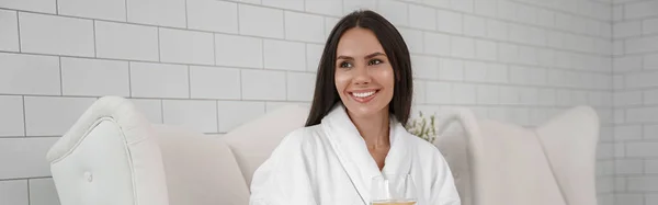 Stock image Woman in white bathrobe drink water during medical procedure in beauty clinic. High quality photo