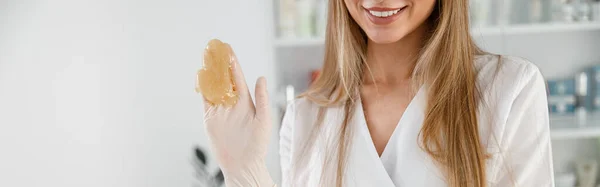 Glimlachende Vrolijke Vrouw Cosmetoloog Handschoenen Toont Materiaal Voor Suiker Ontharing — Stockfoto