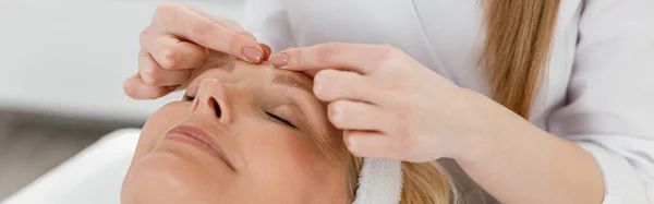Cosmetologist Feminino Está Fazendo Massagem Facial Para Bela Mulher Madura — Fotografia de Stock