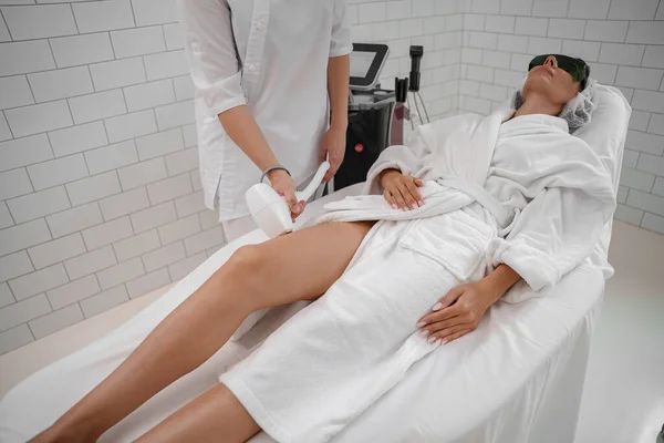 Hair removing procedure of legs. Laser epilation and cosmetology in beauty salon. High quality photo