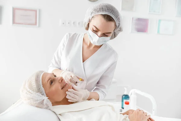 Ganska Professionell Kosmetolog Gör Injektion Till Senior Vit Vacker Kvinna — Stockfoto