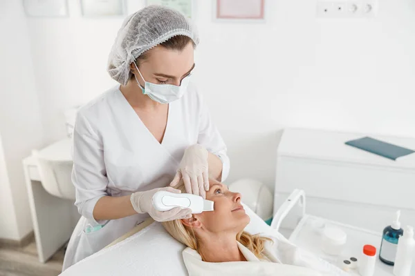 Female Cosmetologist Working Woman Patient Using Ultrasonic Face Scrubber Performing — Stock Photo, Image