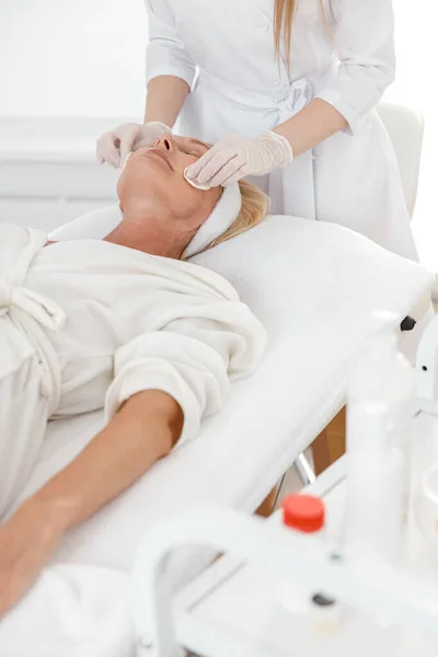 Female Professional Beautician Applying Facial Skincare Product Mature Woman Spa — Stock Photo, Image