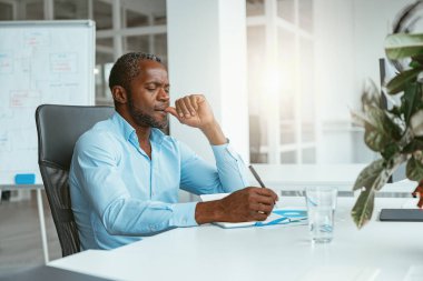 Kendine güvenen Afrikalı işadamı modern ofiste otururken not alıyor. Yüksek kalite fotoğraf