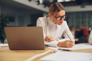 Kadın yönetici modern çalışma masasında notlar alıyor. Yüksek kalite fotoğraf