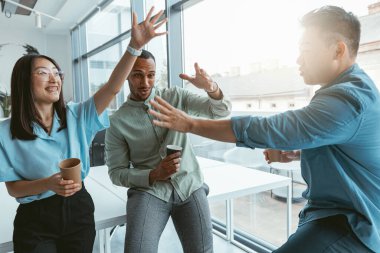 Çok ırklı bir grup güler yüzlü iş arkadaşı kahve içiyor ve tatilde konuşuyor. Yüksek kalite fotoğraf