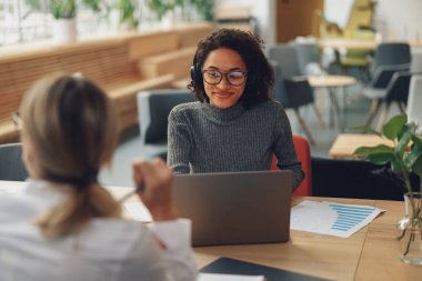 Kadın analist, meslektaşıyla birlikte çalışırken dizüstü bilgisayarda çalışıyor. Yüksek kalite fotoğraf