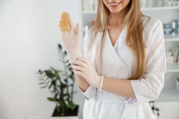Usmívající Šťastná Žena Kosmetolog Rukavicích Ukazuje Materiál Pro Cukrovarnické Depilace — Stock fotografie