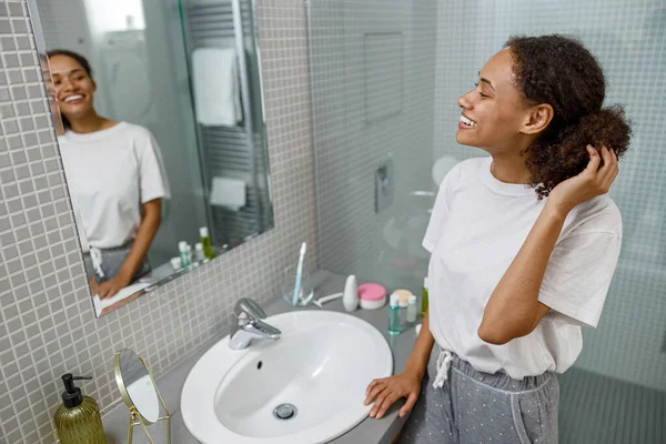 Smiling African Woman Standing Bathroom Looking Mirror High Quality Photo — Stock Photo, Image