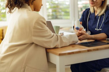 Doktor, klinikte hastaların sıcaklığını termometreyle ölçer. Yüksek kalite fotoğraf