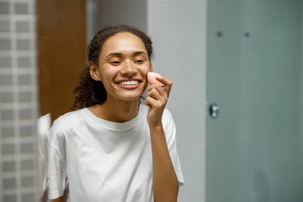 Young Smiling African Woman Sponge Applying Makeup Home Bathroom High — Stock Photo, Image