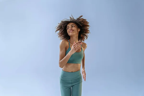 运动活跃的女人跳上演播室的背景 看着旁边 动态运动 — 图库照片