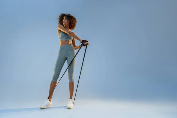 Woman Performs Exercises Expander Studio Background Strength Motivation — Stockfoto