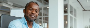 Kendine güvenen Afrikalı işadamı modern ofiste otururken not alıyor. Yüksek kalite fotoğraf