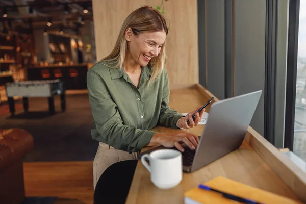 妇女销售经理坐在现代的同事和笔记本电脑上工作 高质量的照片 — 图库照片