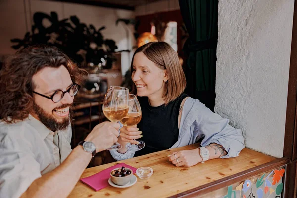 stock image Smiling couple drinking wine at restaurant and clinking glasses. High quality photo