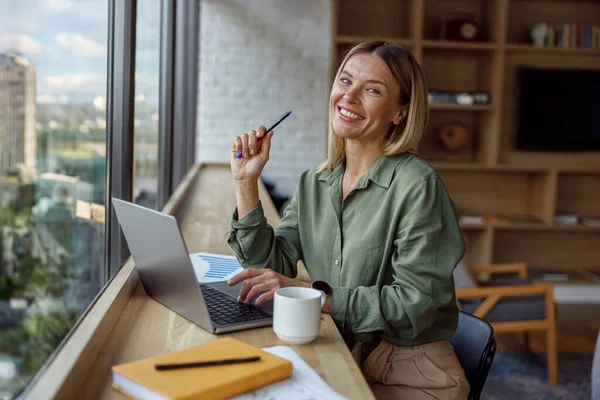 妇女销售经理坐在现代的同事和笔记本电脑上工作 高质量的照片 — 图库照片