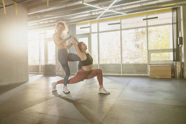 适合女人在私人教练的帮助下在健身房做伸展运动 高质量的照片 — 图库照片