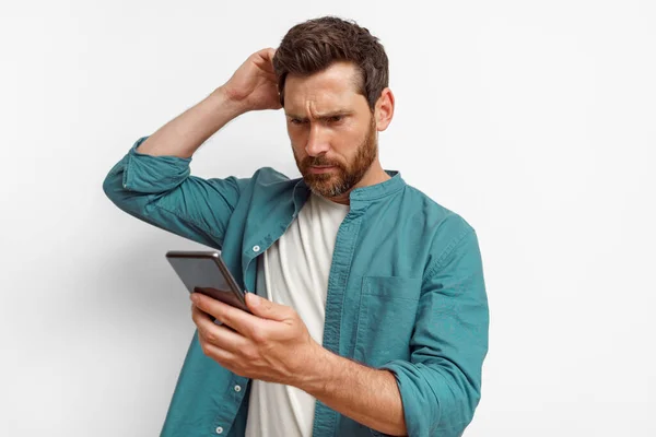 Thoughtful Man Looking His Mobile Phone While Standing White Background — Stock Photo, Image