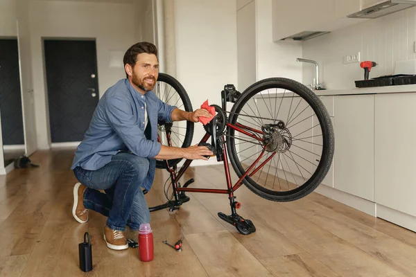 Bonito Homem Roupas Casuais Reparando Própria Bicicleta Casa Foto Alta — Fotografia de Stock