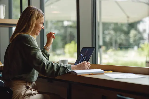 微笑的女企业家在笔记本电脑上工作 在舒适舒适的空间内部做笔记 — 图库照片