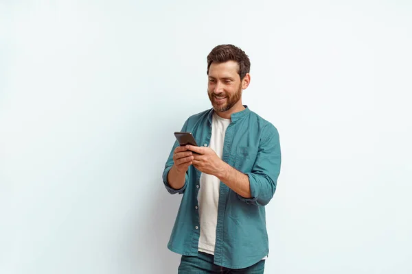 Homem Olhando Para Seu Telefone Celular Enquanto Estava Sobre Fundo — Fotografia de Stock