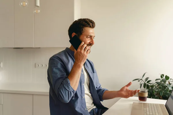 Freelancer Masculino Roupas Casuais Conversando Por Telefone Enquanto Trabalhava Laptop — Fotografia de Stock