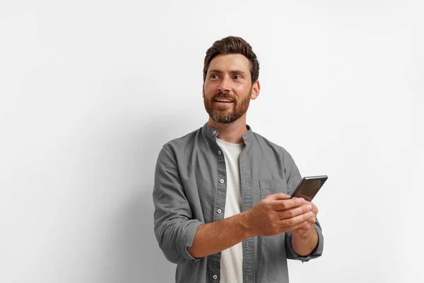 Man Looking Side Holding Mobile Phone While Standing White Background — Stock Photo, Image