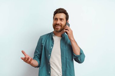 Beyaz arka planda dururken cep telefonuyla konuşan gülümseyen adam. Yüksek kalite fotoğraf