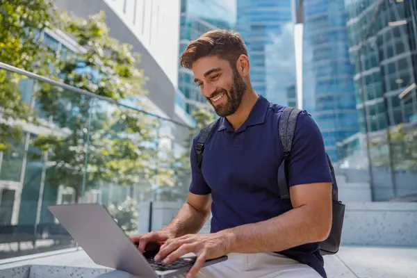 商人坐在城市摩天大楼的背景上 带着笔记本电脑 高质量的照片 — 图库照片