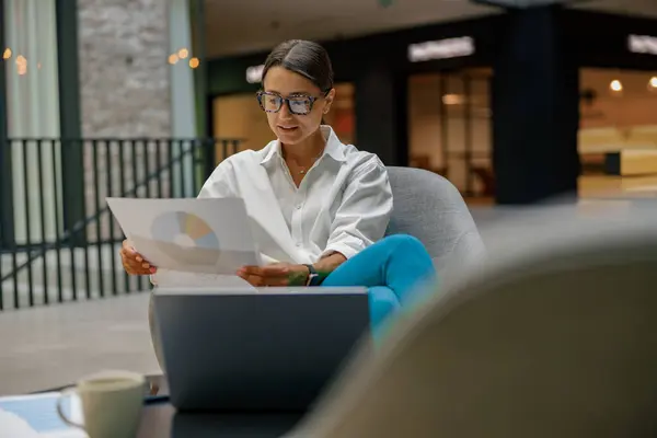 坐在现代办公背景的笔记本电脑上工作的有重点的时髦女商人 — 图库照片