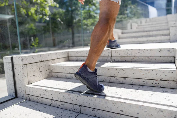 Close up of legs sport runner man running up stairs doing cardio workout at outdoor street