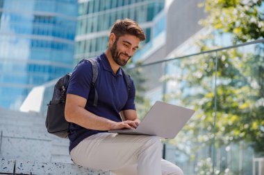 Şehrin gökdelenlerinde dizüstü bilgisayarı olan bir iş adamı. Yüksek kalite fotoğraf