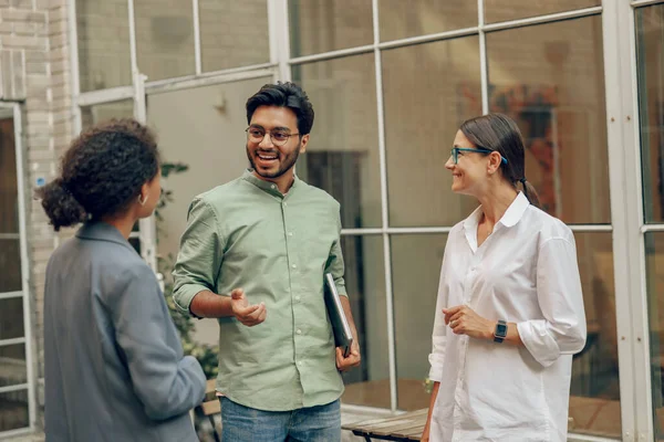 Professional business team talks during break standing on background of modern office building
