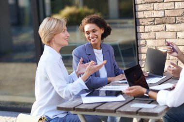 Yaratıcı ekip açık kafede toplantı sırasında projede işbirliği yapıyor. İş kavramı