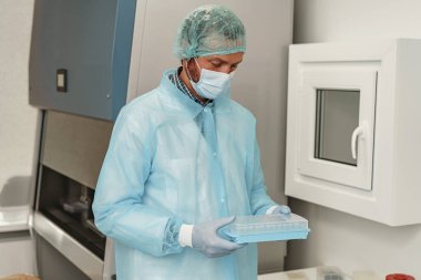 Üniformalı bilim adamı laboratuarda test tüpleri tutuyor. Kimya alanında tıp ve araştırma