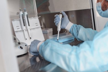 Bilim adamı araştırma laboratuarında test tüpüne madde bırakıyor. Bilim ve biyokimya kavramı