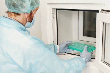 Üniformalı bilim adamı laboratuarda test tüpleri tutuyor. Kimya alanında tıp ve araştırma