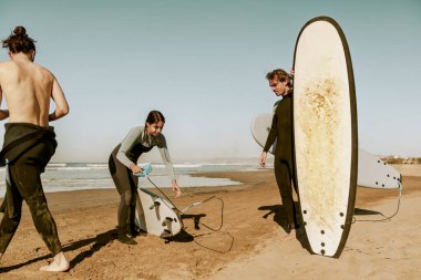 Dalgıç kıyafetli sörfçüler sörf tahtasıyla dalgalara binmeye hazırlanıyorlar. Yüksek kalite fotoğraf