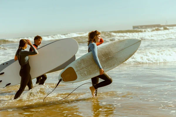 Visão Traseira Grupo Amigos Com Pranchas Surf Roupa Mergulho Entrando — Fotografia de Stock