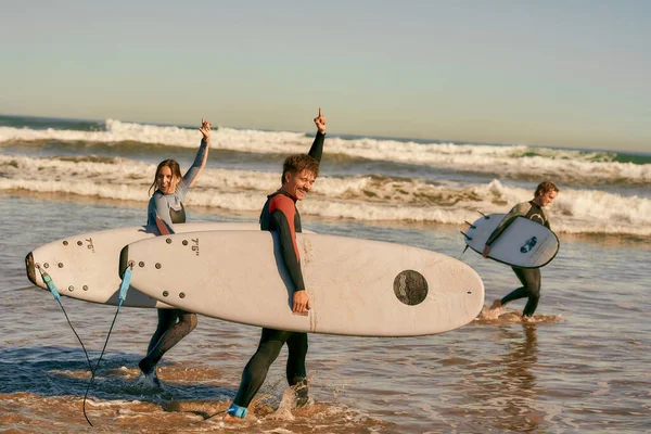 Surferzy Spotyka Przyjaciół Machając Ręką Podczas Noszenia Deski Surfingowej Plaży — Zdjęcie stockowe