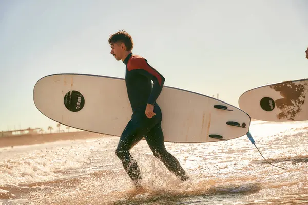 Widok Boczny Surferów Wbiegających Morza Trzymających Deski Surfingowe Wysokiej Jakości — Zdjęcie stockowe