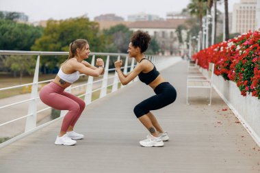 İki gülümseyen zinde kadın dışarıda antreman yapıyor. Etkin yaşam tarzı kavramı 